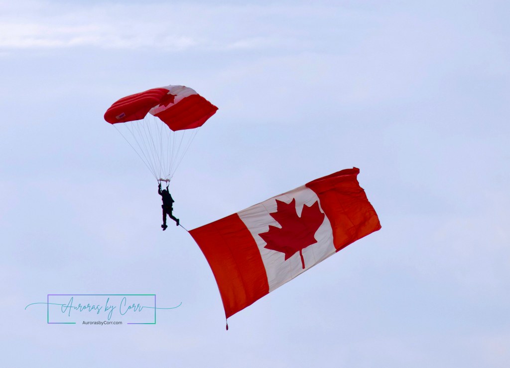 Members of the Canadian Armed Forces Parachute Team, the SkyHawks, perform with the Canadian Flag during the Cold Lake Air Show 2026
