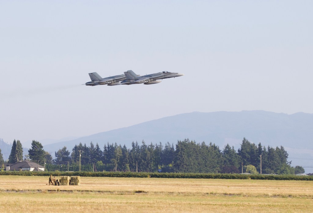 2 CF-18 Hornets perform a tactical flyover of enemy troops on the ground, letting their presence be known.