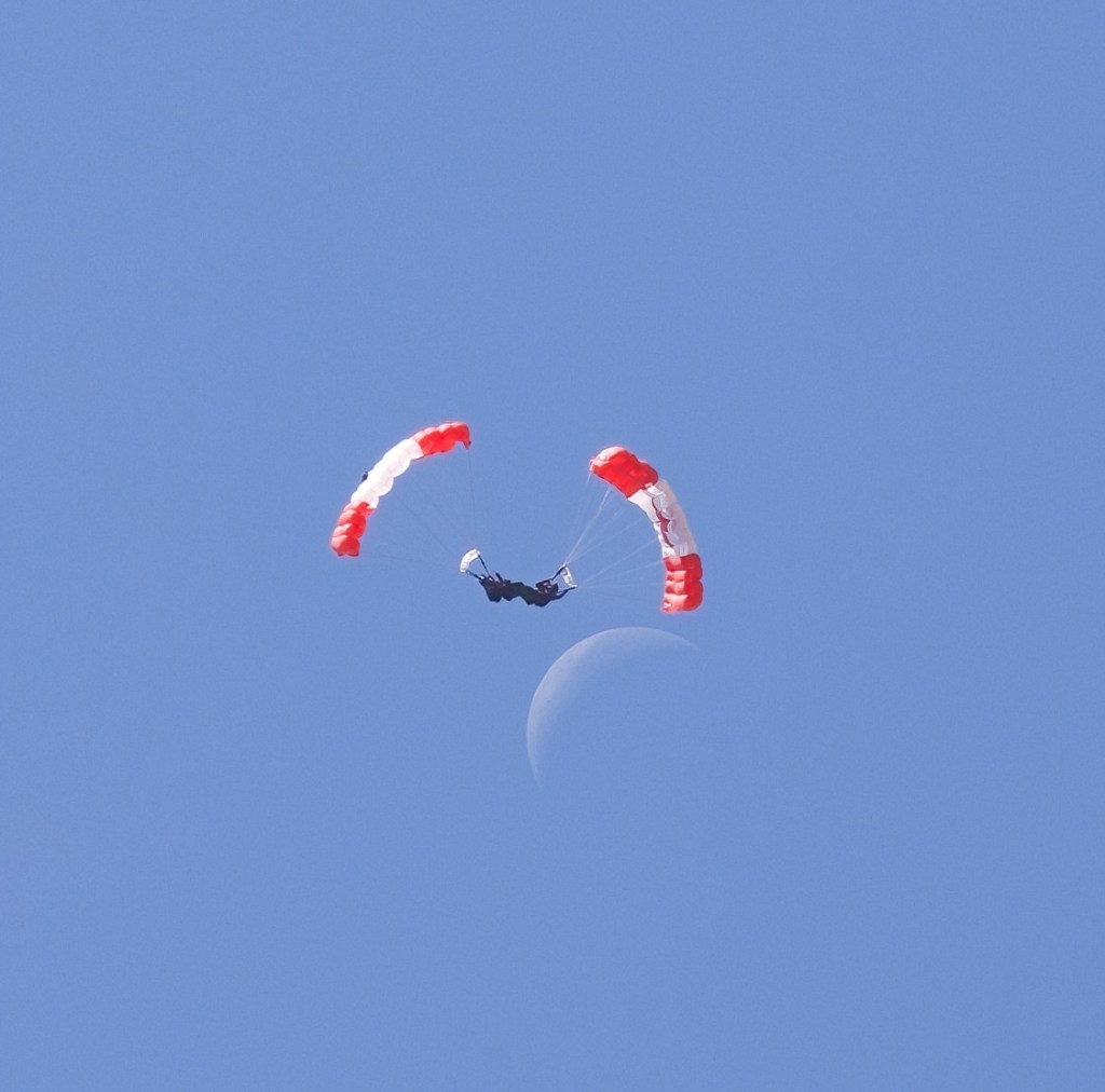 A pair of RCAF Skyhawks take to the sky at the 2026 Abbotsford Air Show, seemingly soaring next to the daytime crescent moon.
